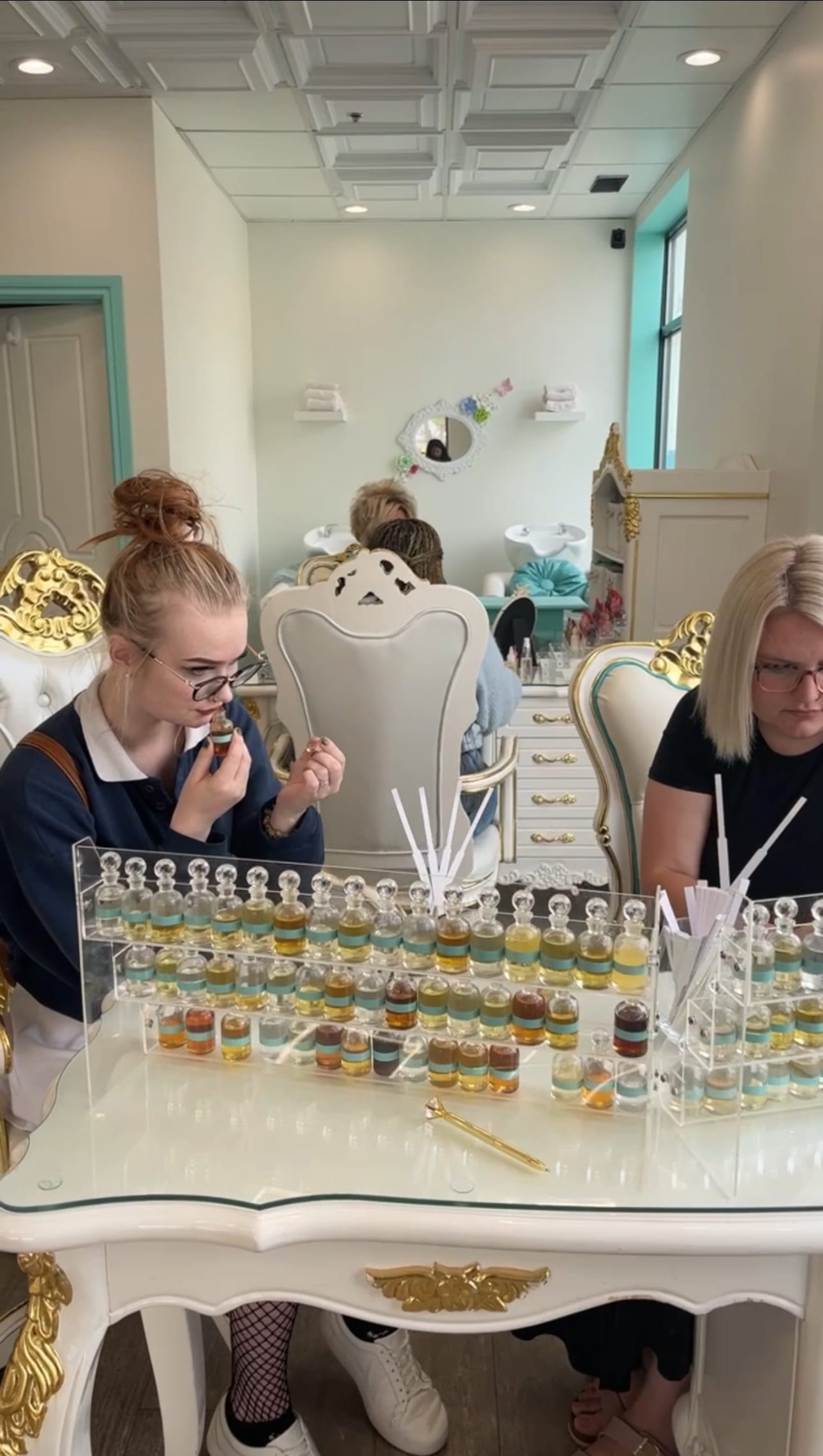 About us and out story. women sitting at perfumer's organ smelling fragrance notes to create bespoke perfume Crème de la Crème Beauty Lounge
